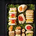 Bandeja de catering con una selección de mini bocadillos y pasteles.