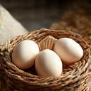 Cesta de mimbre con huevos frescos y un saco de harina de trigo.